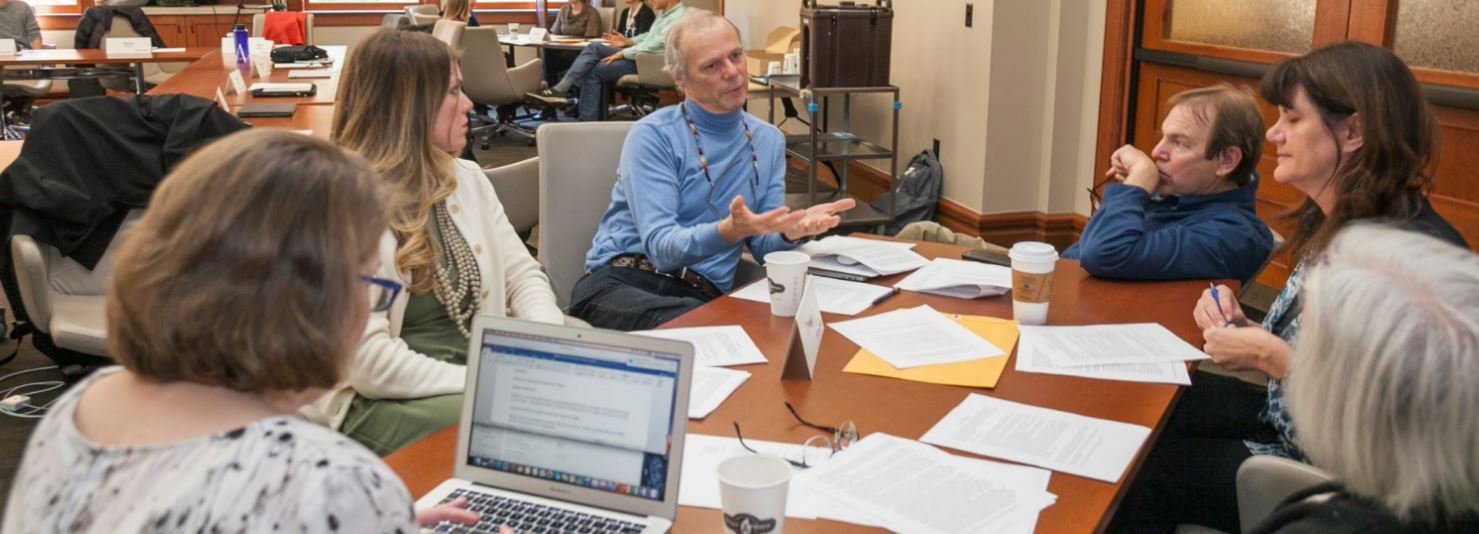 Group gathered around a table discussing a topic